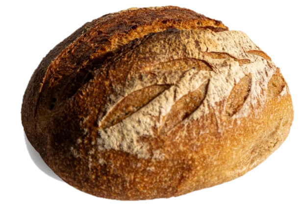 Okrugao hleb Locus Sourdough, posut brašnom, sa zarezima u obliku klasa i tamnozlatnom korom.