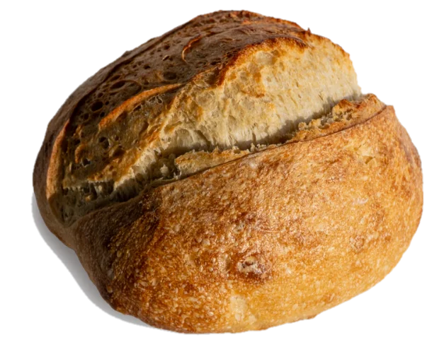 Okrugao hleb Locus Sourdough, posut brašnom, sa zarezima u obliku klasa i tamnozlatnom korom.